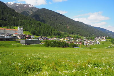 Houses on field by mountains against sky