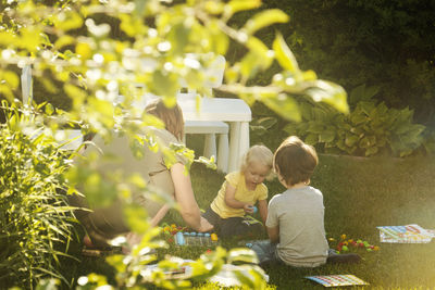 Mom and children playing in the garden in backyard.