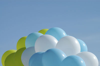 Low angle view of balloons against blue sky