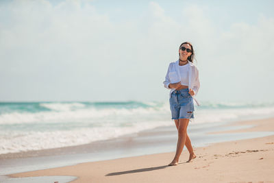 Portrait of young woman standing at beach