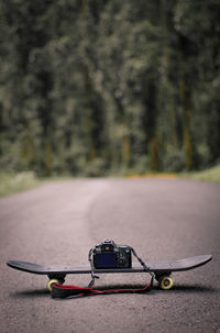 Close-up of camera and skateboard on road