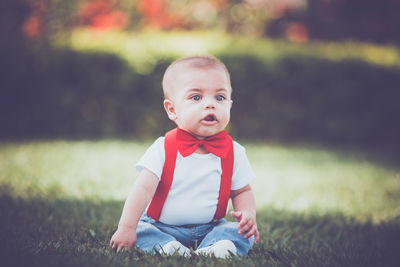 Portrait of cute boy sitting on field