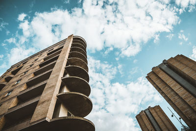 Low angle view of buildings against cloudy sky