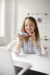 Girl looking away while sitting on table