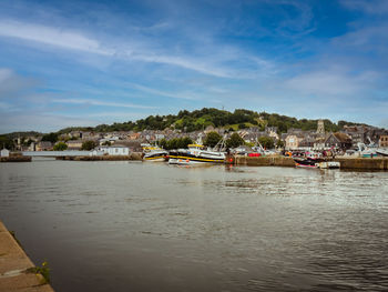 Scenic view of sea by buildings against sky