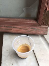 High angle view of leftover tea in disposable cup on window sill