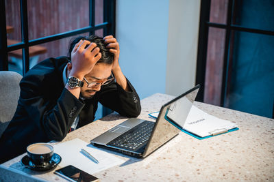 Young businesswoman using laptop at office