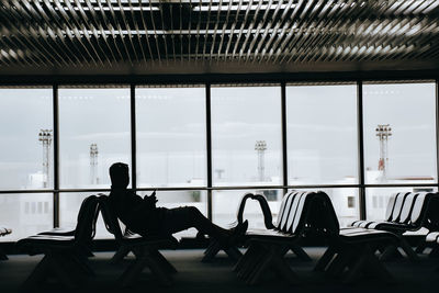 Silhouette of people sitting on chair at airport