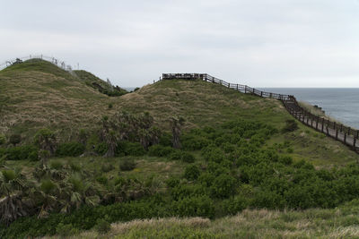 Scenic view of landscape by sea against sky