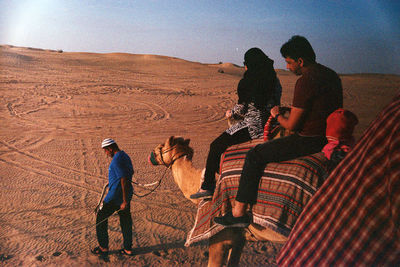 Rear view of people standing on desert