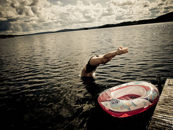 Full length of shirtless man floating in lake