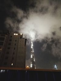 View of illuminated buildings against cloudy sky