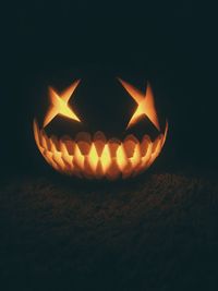 Close-up of illuminated pumpkin against black background