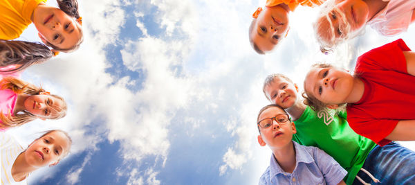 Low angle view of smiling woman against sky