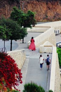 People walking on footpath by building