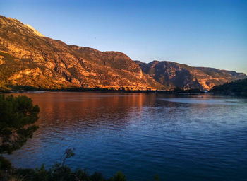 Calm countryside lake against mountain range