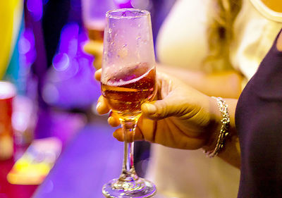 Midsection of woman drinking glass