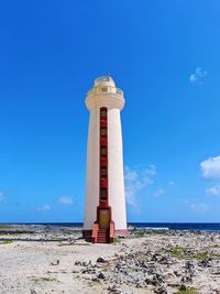 Lighthouse by sea against sky