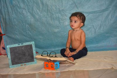 Portrait of shirtless boy playing with toy