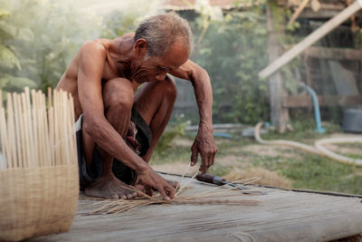 Old man are weaving in the countryside of thailand.