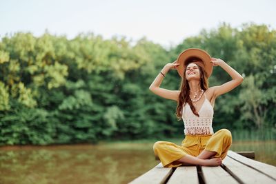 Portrait of young woman sitting on railing