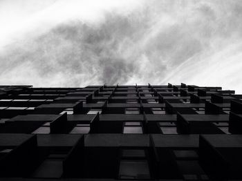 Low angle view of modern building against cloudy sky