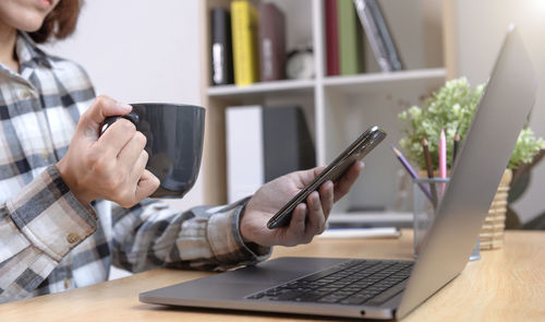 Midsection of man using laptop on table