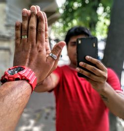 Midsection of man holding mobile phone