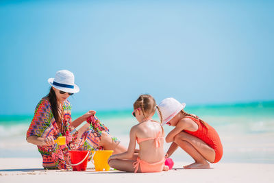 People sitting on beach against sky