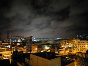 Illuminated cityscape against sky at night