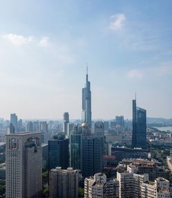 Aerial view of buildings in city against cloudy sky