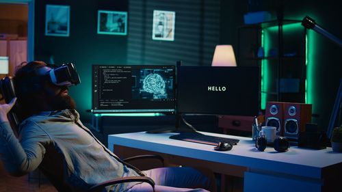 Rear view of woman using laptop at home