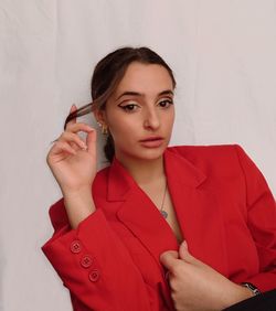 Portrait of beautiful woman standing against wall