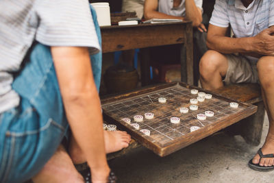 Low section of men playing board game outdoors