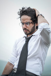 Portrait of young man standing against wall