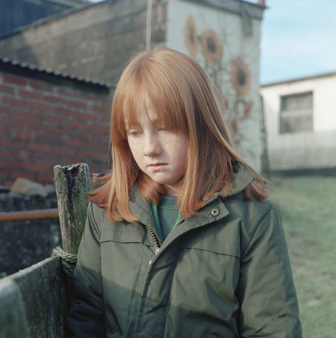 one person, real people, architecture, child, built structure, girls, building exterior, childhood, lifestyles, clothing, day, females, portrait, hair, women, front view, leisure activity, focus on foreground, warm clothing, hairstyle, outdoors, innocence, bangs, contemplation