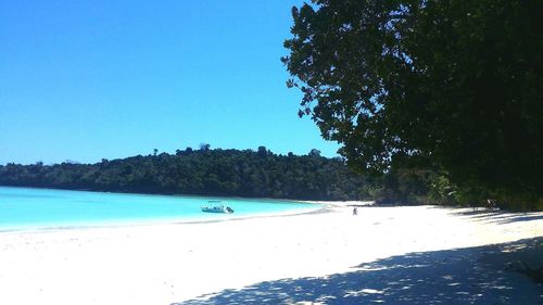 Scenic view of beach against clear blue sky