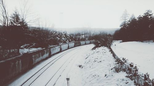 Snow covered landscape against clear sky