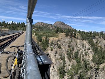 Panoramic view of railroad tracks by mountain against sky