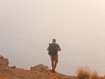 Rear view of man standing on rock