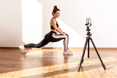 Side view of woman exercising on hardwood floor at home