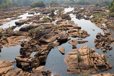 Rock formation amidst water against sky