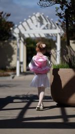 Rear view of woman walking with umbrella