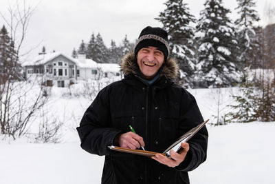 Portrait of smiling woman standing in snow