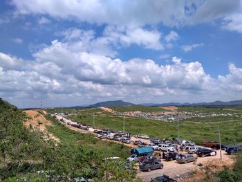 High angle view of road amidst field against sky