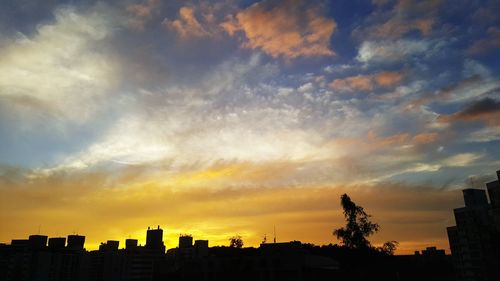 Silhouette buildings against sky during sunset