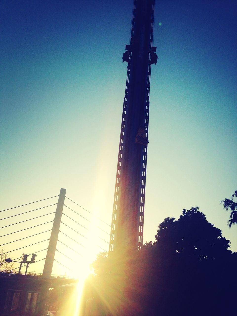 sun, clear sky, low angle view, sunlight, sunbeam, lens flare, sunset, silhouette, blue, built structure, copy space, architecture, bright, outdoors, sky, tree, no people, nature, sunny, back lit