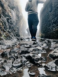 Low section of man standing on rock