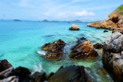 Close-up of rocks in sea against sky