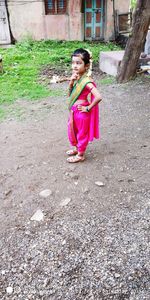 Side view of smiling girl standing outdoors